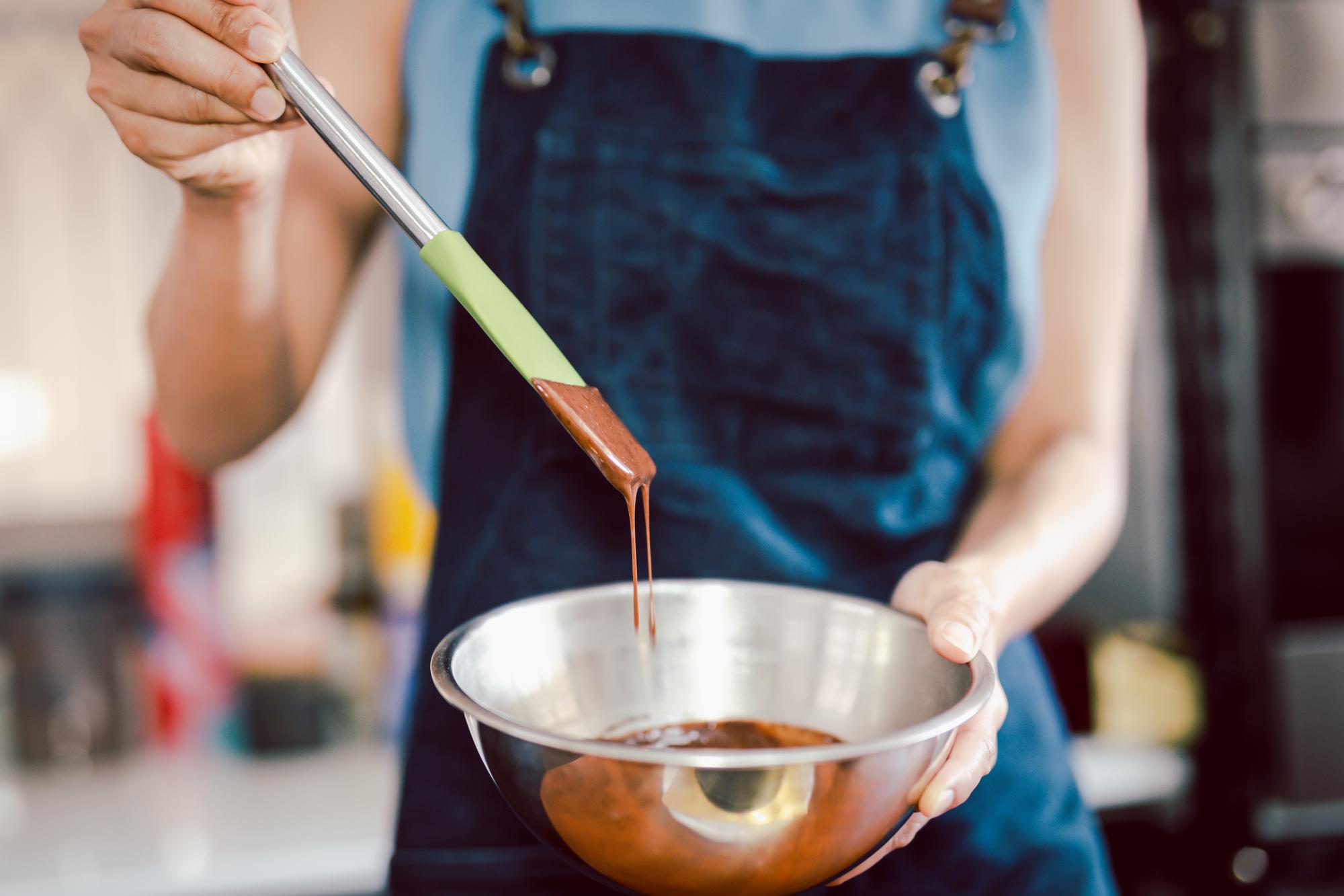 Hands finishing sauce in pan